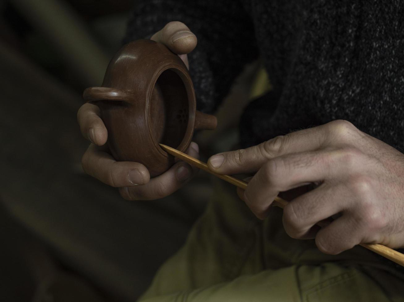 l'artisan fabrique une théière chinoise traditionnelle à partir d'argile de yixing photo