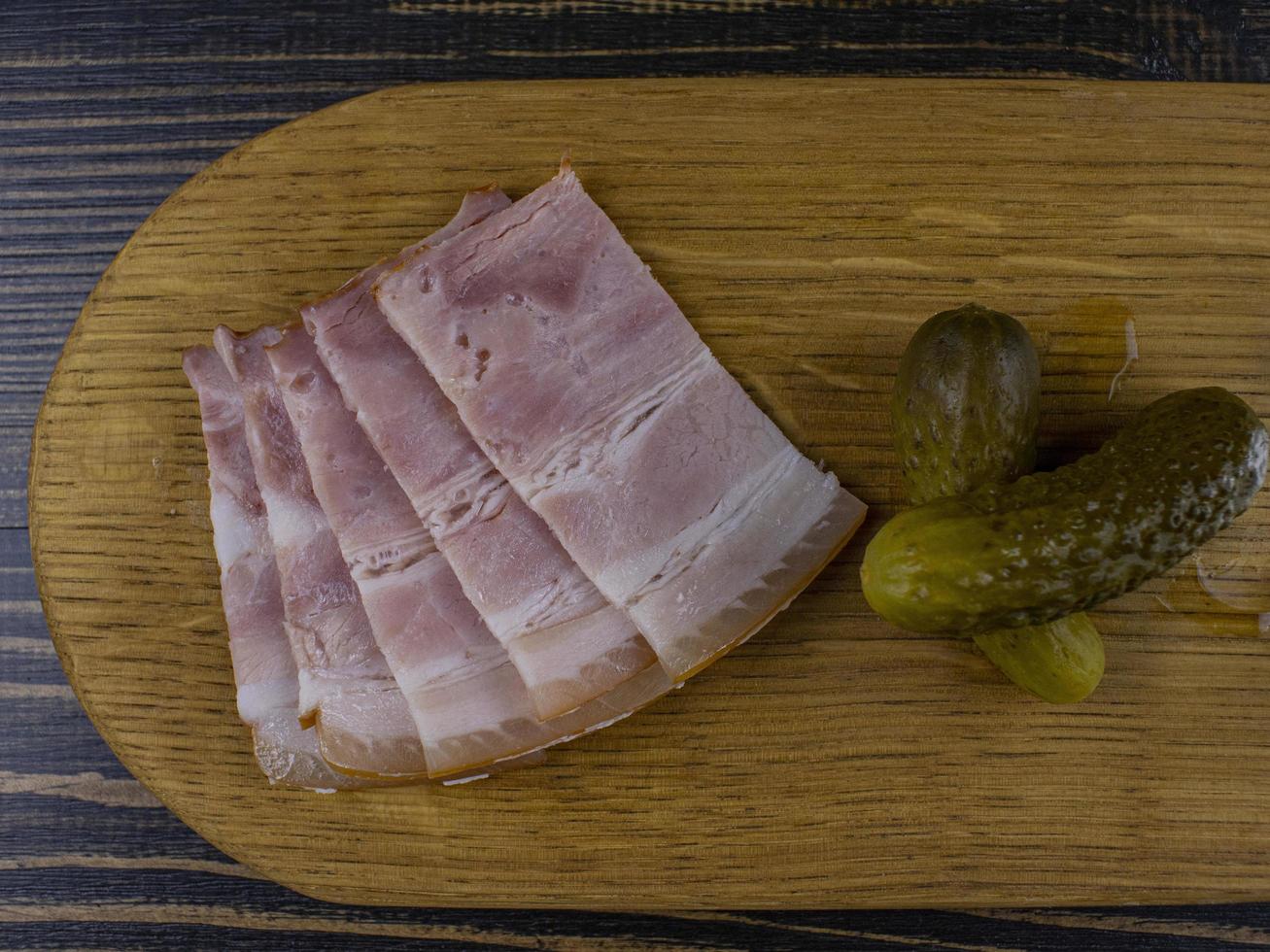 bacon et cornichons sur une planche de bois. collation traditionnelle russe photo