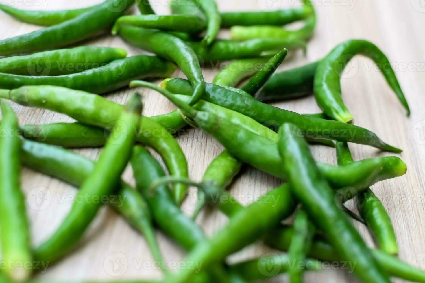 Frais vert le Chili poivre sur plaine en bois tableau, vert essentiel des légumes pour tout essentiel nourriture, vue de non pelé des légumes avec plaine Contexte photo