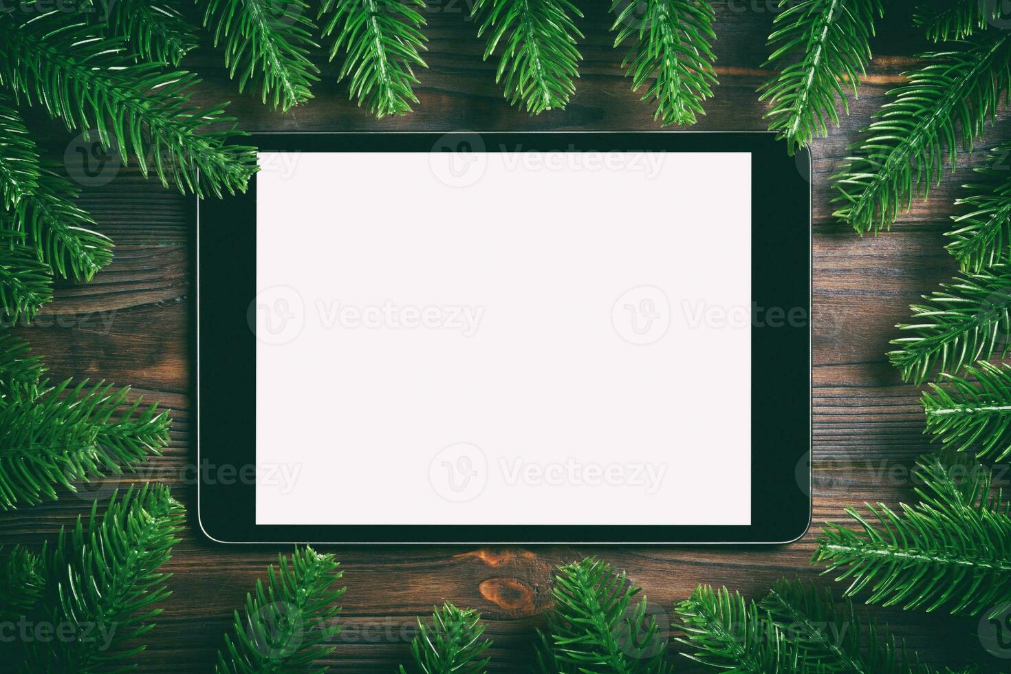 vue de dessus de tablette ornée d'un cadre en sapin sur fond de bois. concept de temps du nouvel an photo