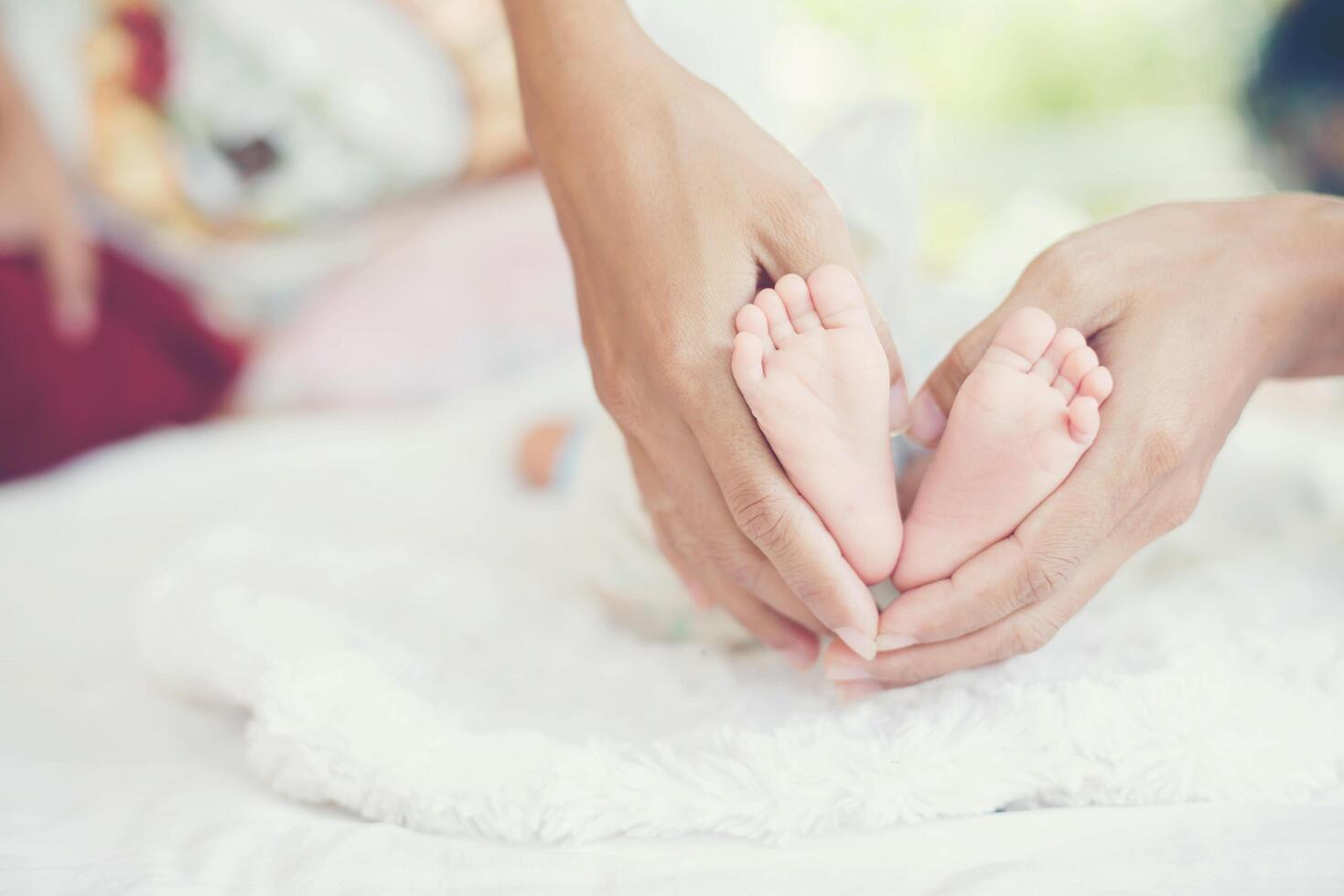 pieds de bébé nouveau-né dans les mains de la mère. photo