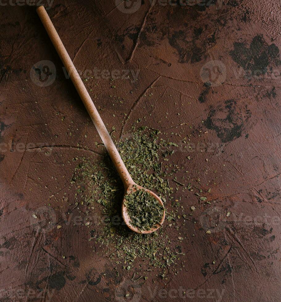une pile de une vert pimenter mélanger séché des légumes et herbes sur en bois cuillère photo