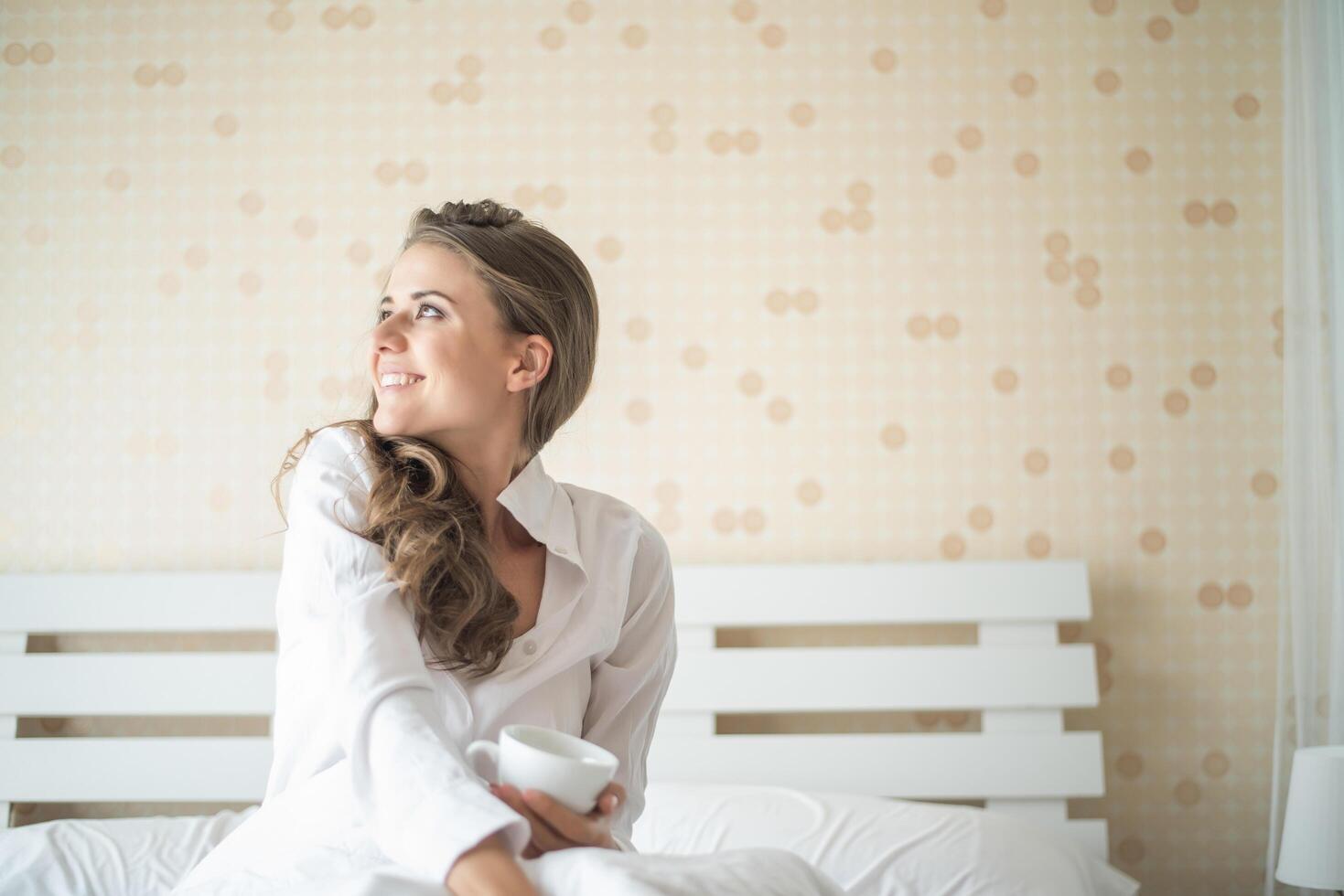 belle femme dans sa chambre buvant du café le matin photo