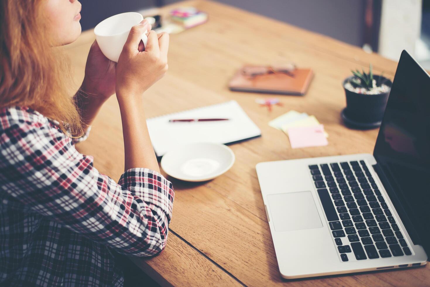 jeune femme d'affaires assise au bureau avec une tasse de café prête. photo