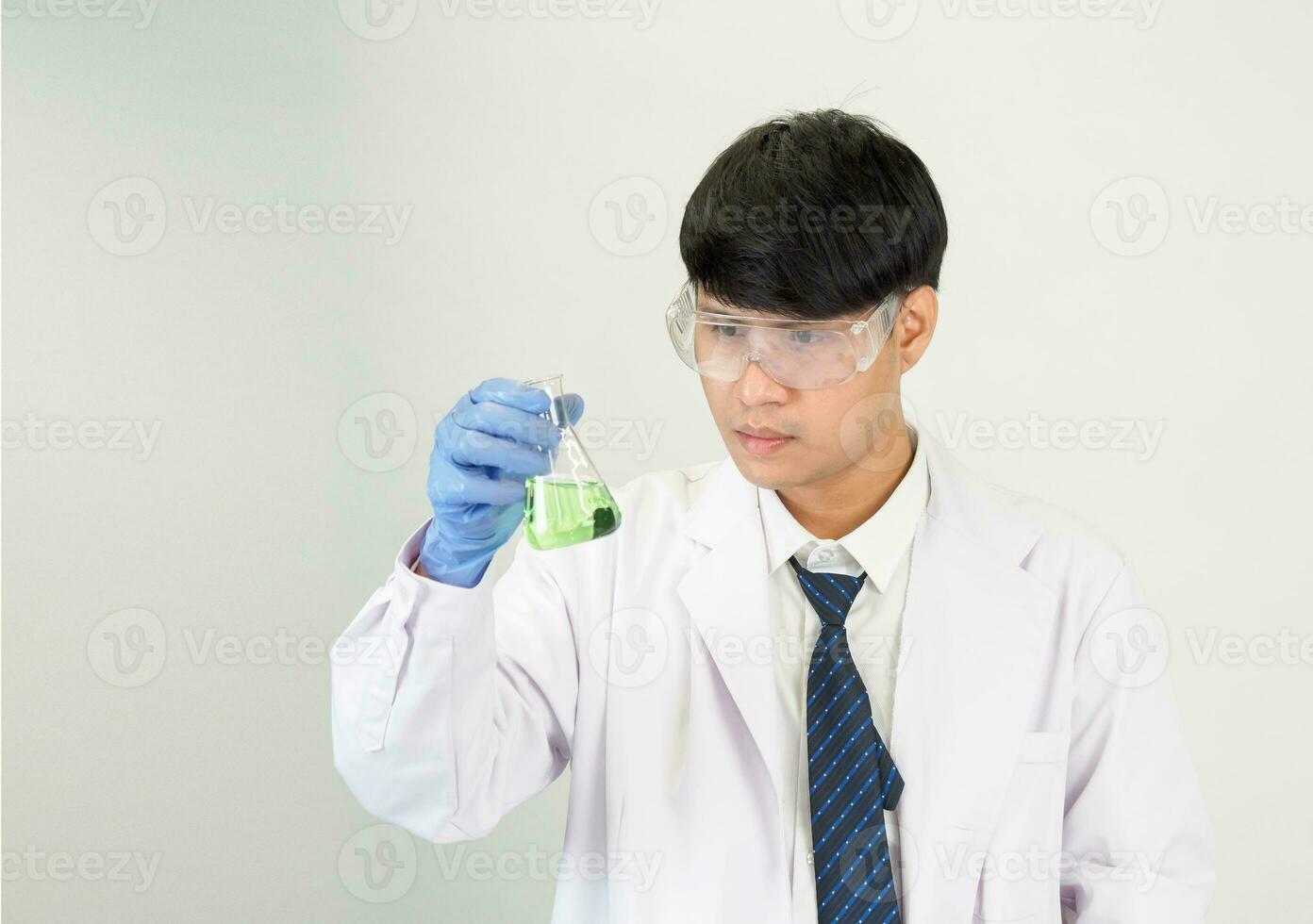 asiatique homme étudiant scientifique ou médecin Regardez main en portant dans réactif mélange laboratoire dans une science recherche laboratoire avec tester tubes de divers tailles dans laboratoire chimie laboratoire blanc Contexte. photo