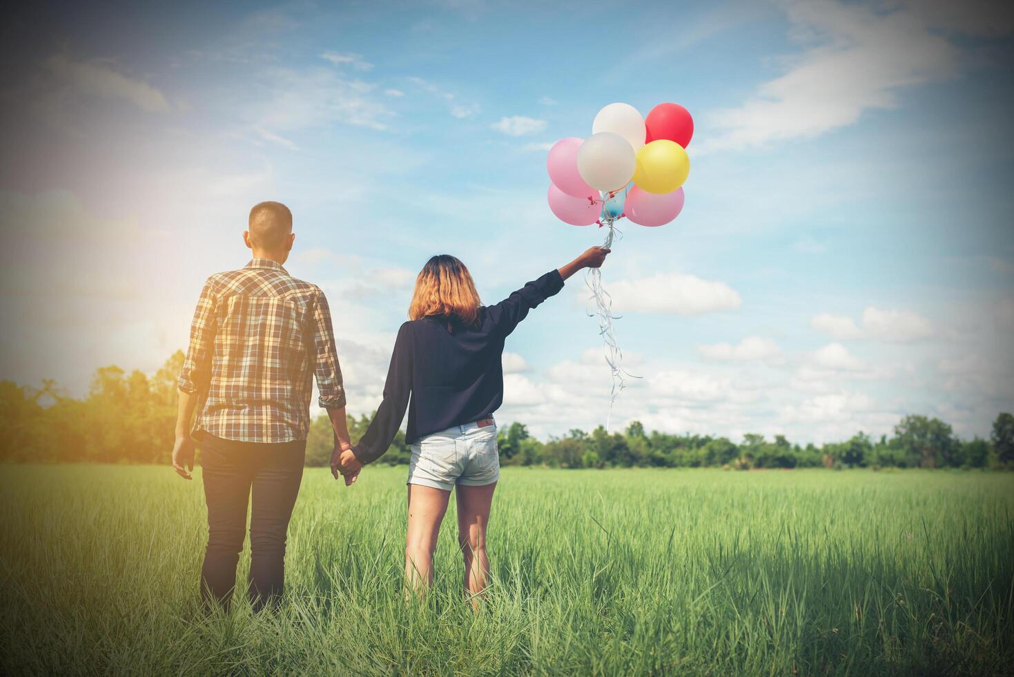 dos d'un jeune couple asiatique heureux tenant un ballon et marchant ensemble. photo