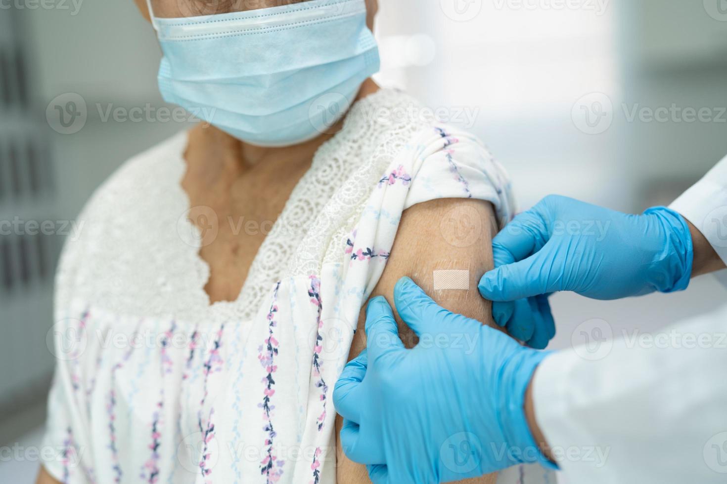 femme âgée asiatique portant un masque recevant le vaccin contre le coronavirus photo