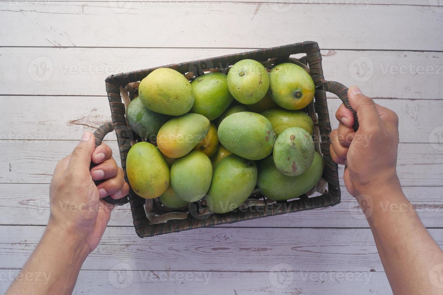 mangue verte fraîche dans un bol sur la table photo
