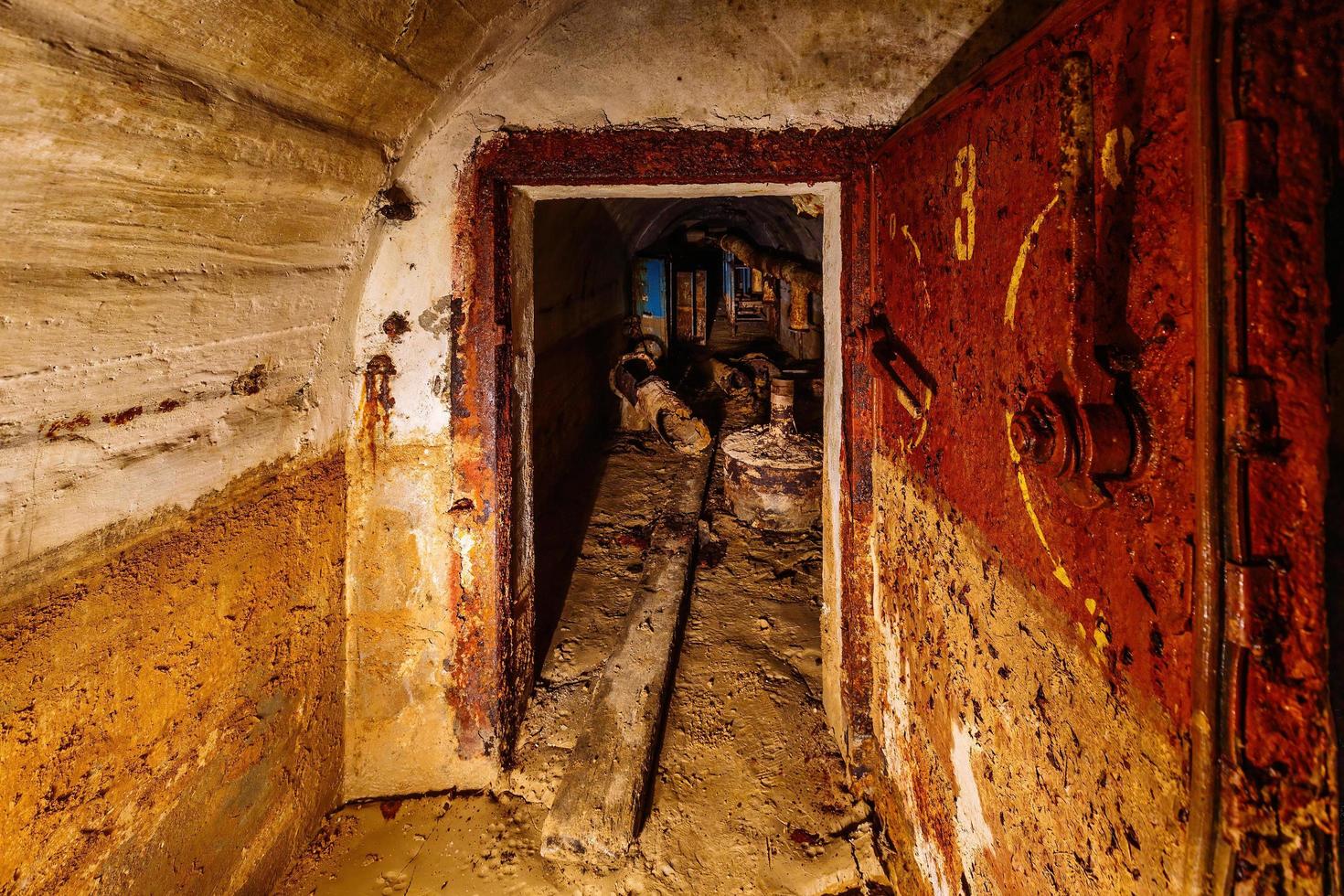 Porte blindée en métal rouillé dans le vieux bunker soviétique sale abandonné photo