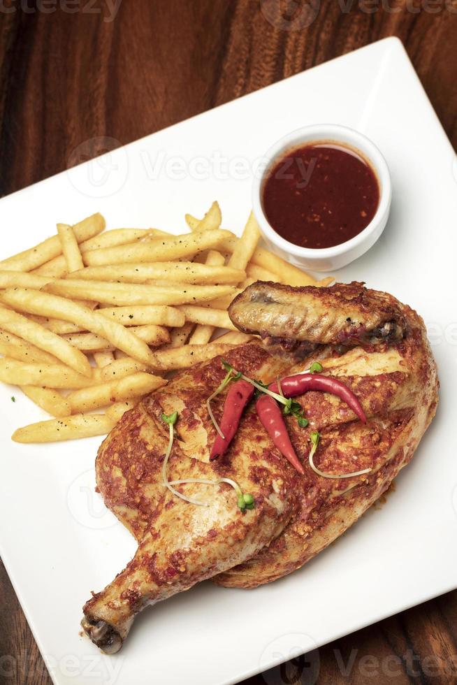 Piri piri portugais épicé demi poulet rôti avec frites sur plaque au restaurant de lisbonne photo