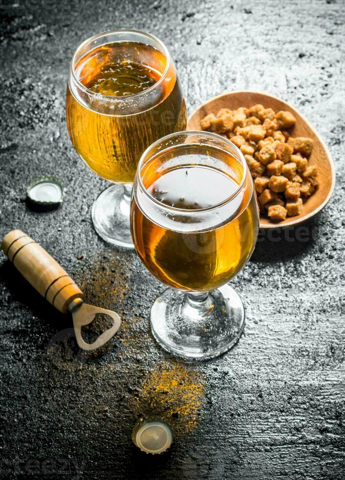 Bière dans des lunettes et les miettes sur une plaque. photo