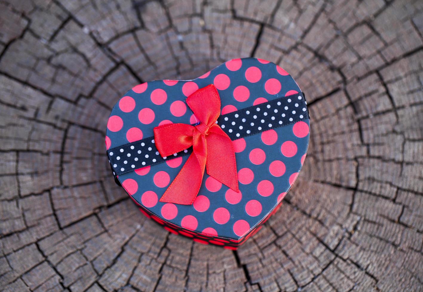 forme de coeur de boîte-cadeau sur tronc de bois photo