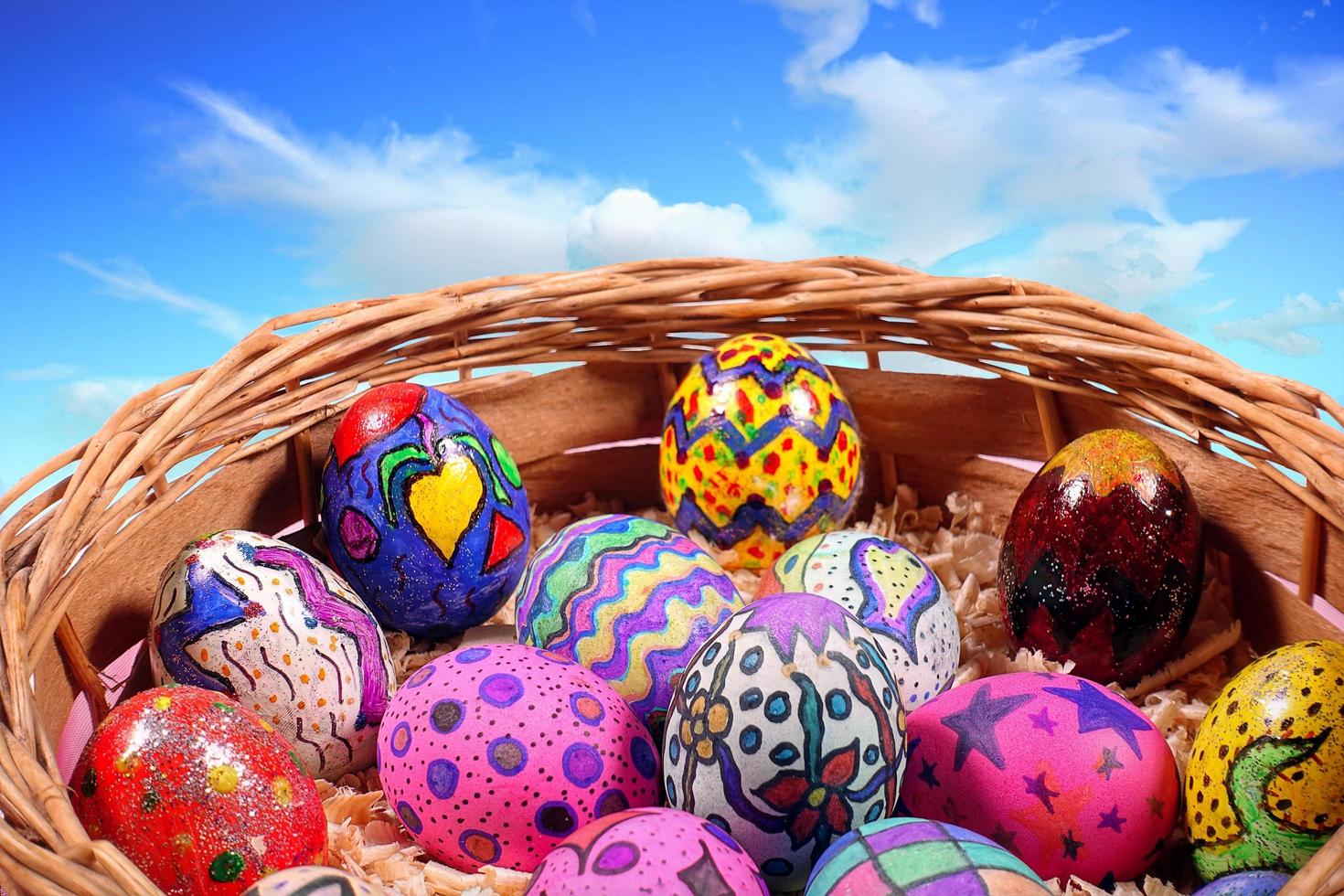 oeufs de pâques colorés dans un panier en bois photo