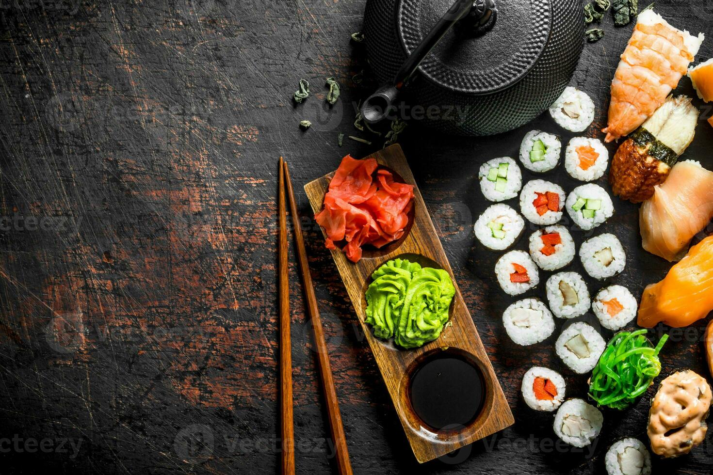 différent les types de Japonais Sushi, Rouleaux et maki avec sauce, wasabi et vert thé dans une théière. photo