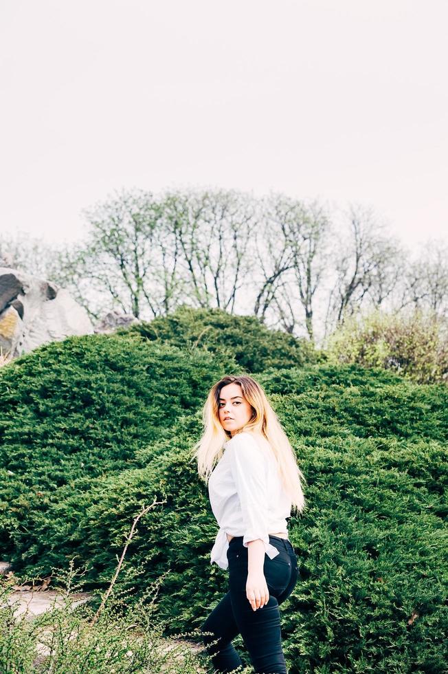 une jolie jeune fille aux cheveux longs marchant dans un parc photo