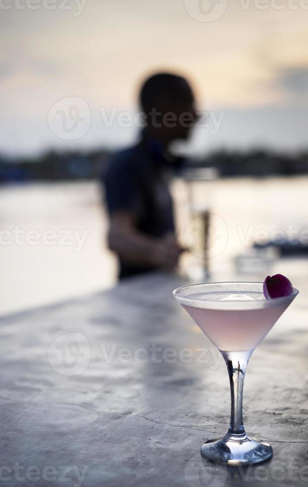 cocktail exotique de vodka martini infusé de litchi et de jasmin au bar asiatique au coucher du soleil photo