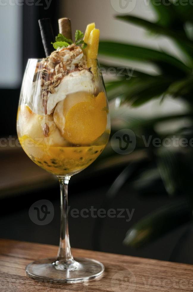 Coupe glacée tropicale à la mangue et aux fruits de la passion biologique dans un verre à vin photo