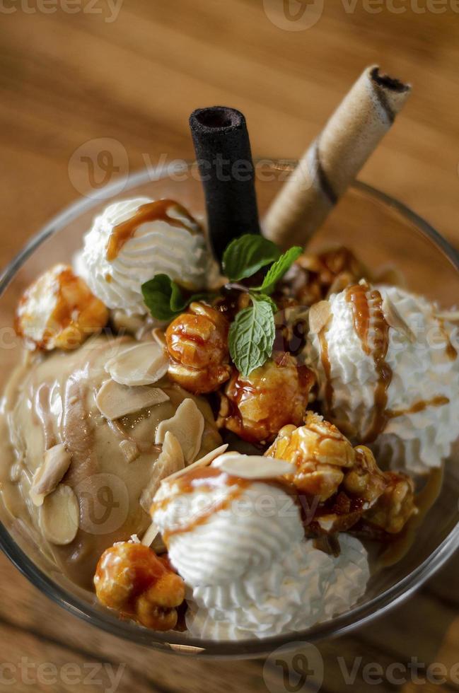 crème glacée au caramel et aux amandes avec dessert sundae au maïs soufflé caramélisé dans un bol en verre photo