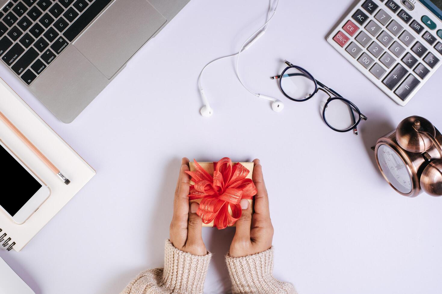 vue de dessus main tenant une boîte-cadeau sur l'espace de travail. photo