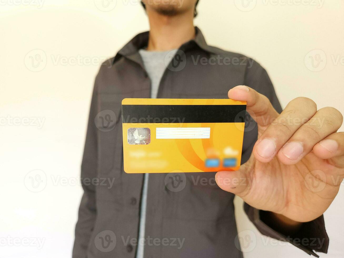 homme en portant et montrant un Orange crédit carte photo