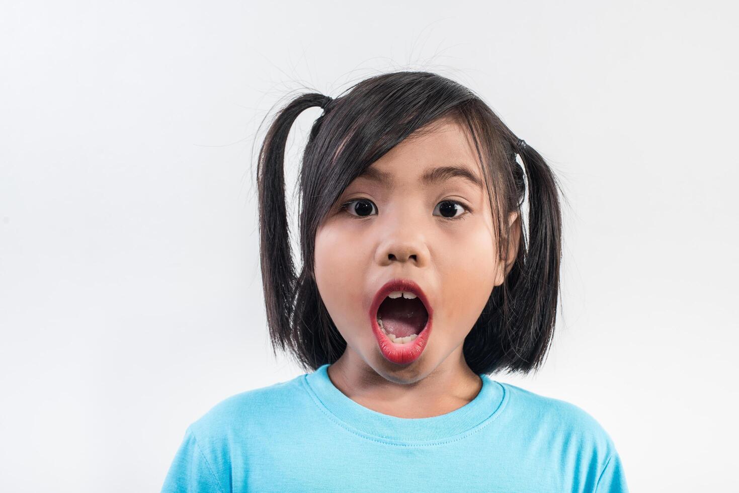 portrait de petite fille drôle agissant en studio shot. photo