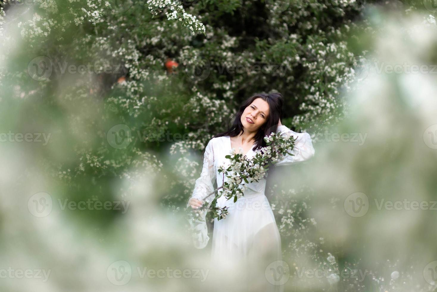 portrait de jeune femme dans le parc dans les branches fleuries photo