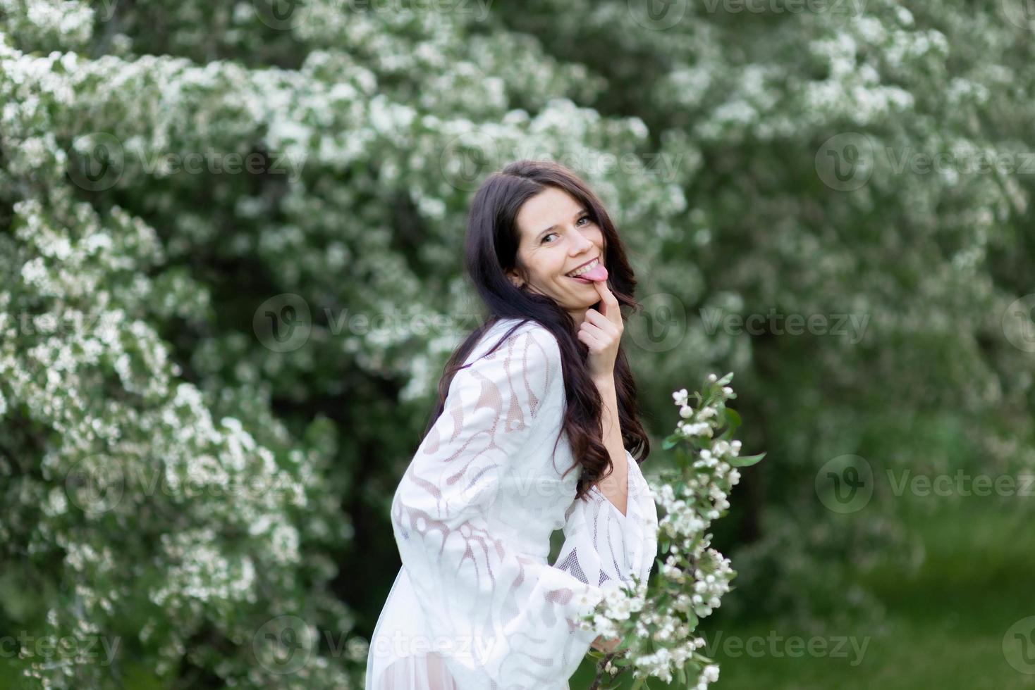 portrait de jeune femme dans le parc dans les branches fleuries photo