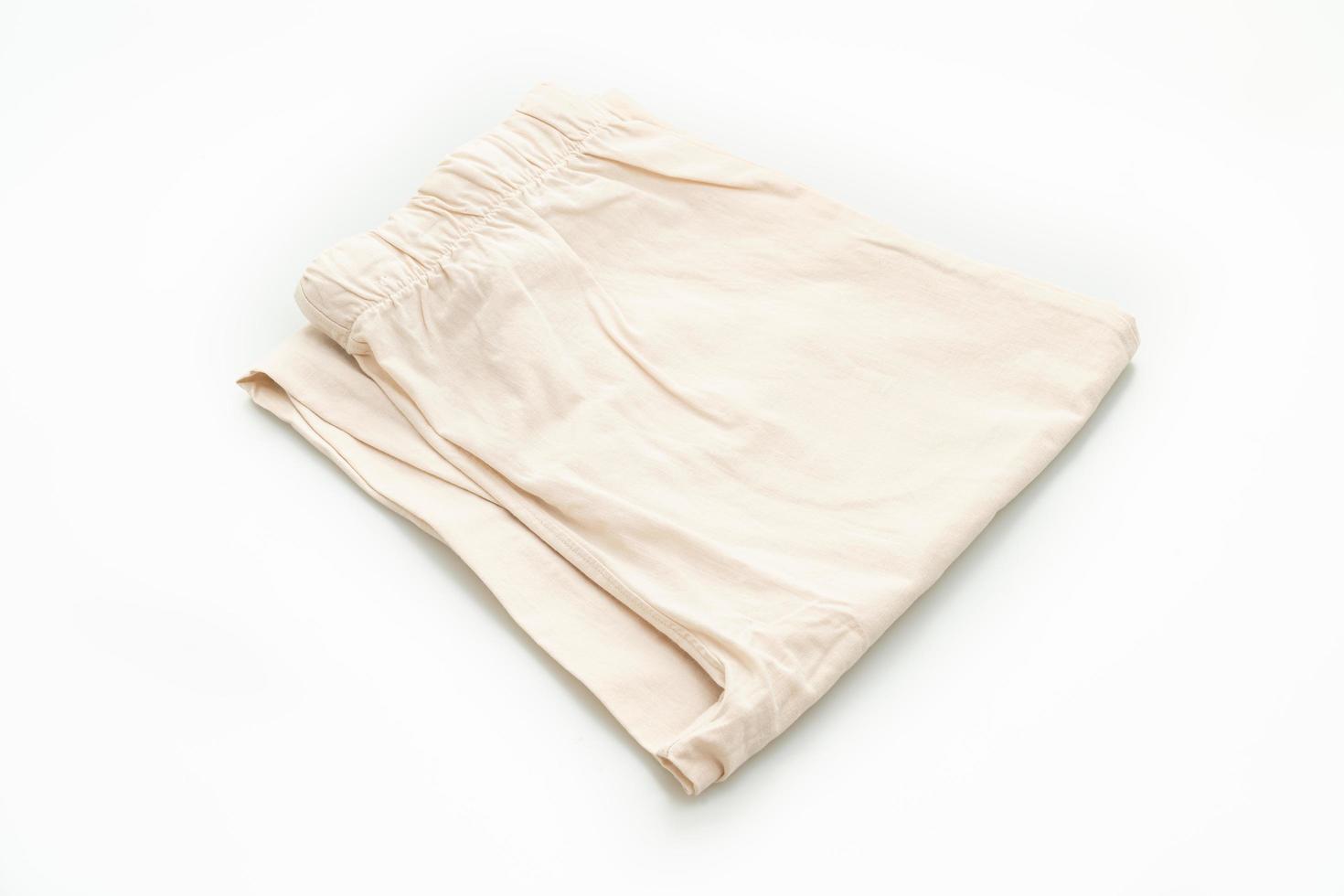 Pantalon beige plié isolé sur fond blanc photo