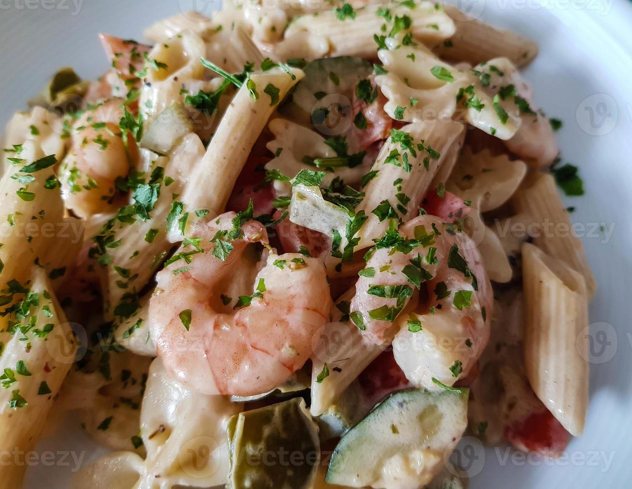 poêle à nouilles colorées avec légumes et crevettes tigrées blanches photo