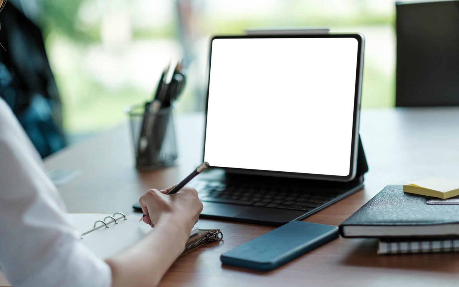 femme d'affaires main travaillant sur un ordinateur et écrivant sur une note photo