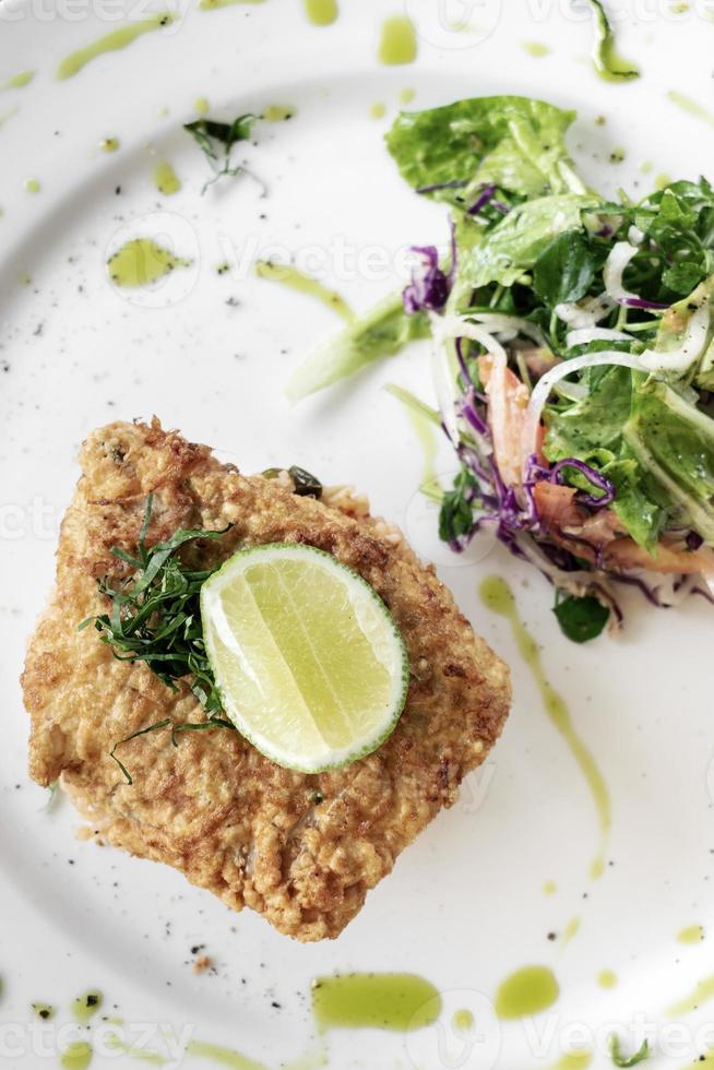 filet de poisson de morue pané frais frit déjeuner léger d'été repas avec riz épicé aux légumes mélangés basque et salade photo