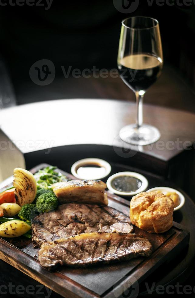 Rôti de boeuf gastronomique du dimanche repas britannique traditionnel sur une vieille table de pub en bois photo