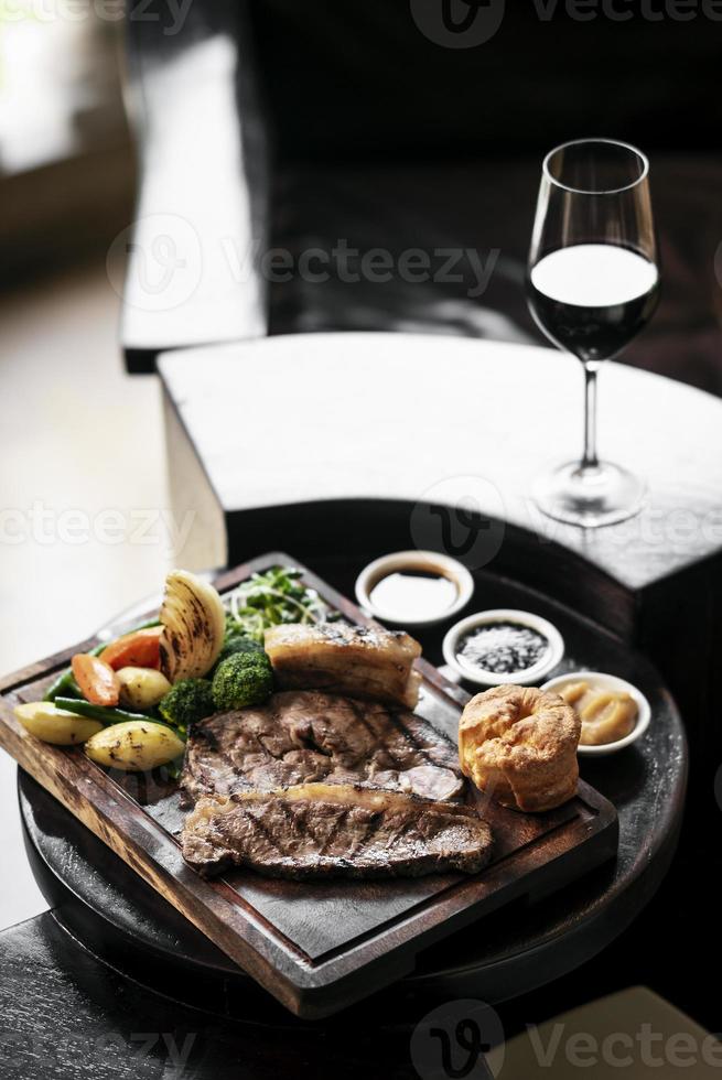 Rôti de boeuf gastronomique du dimanche repas britannique traditionnel sur une vieille table de pub en bois photo