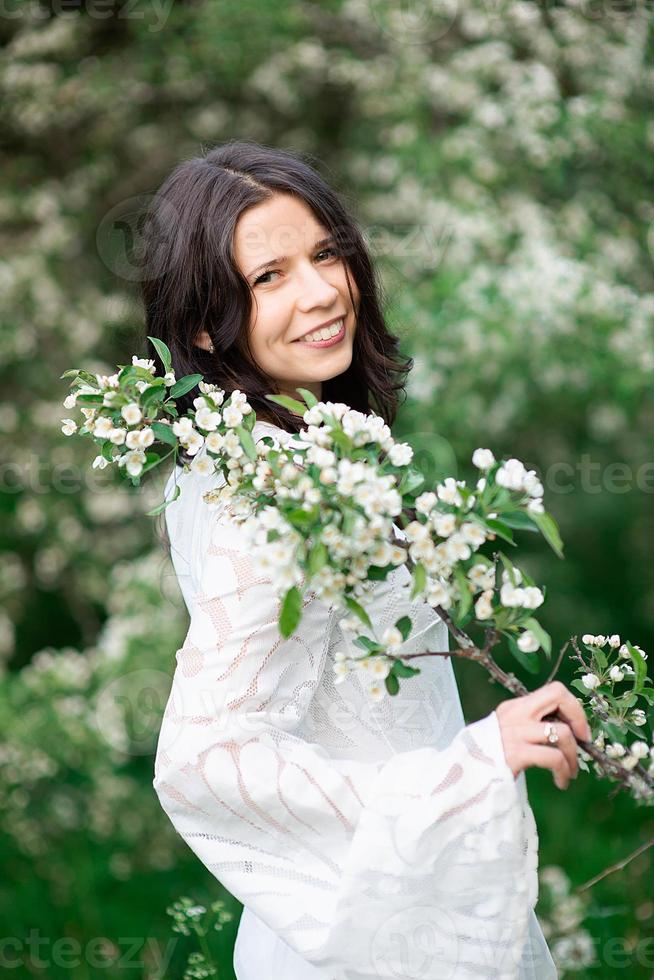 portrait d'une belle jeune femme dans le parc en branches fleuries photo