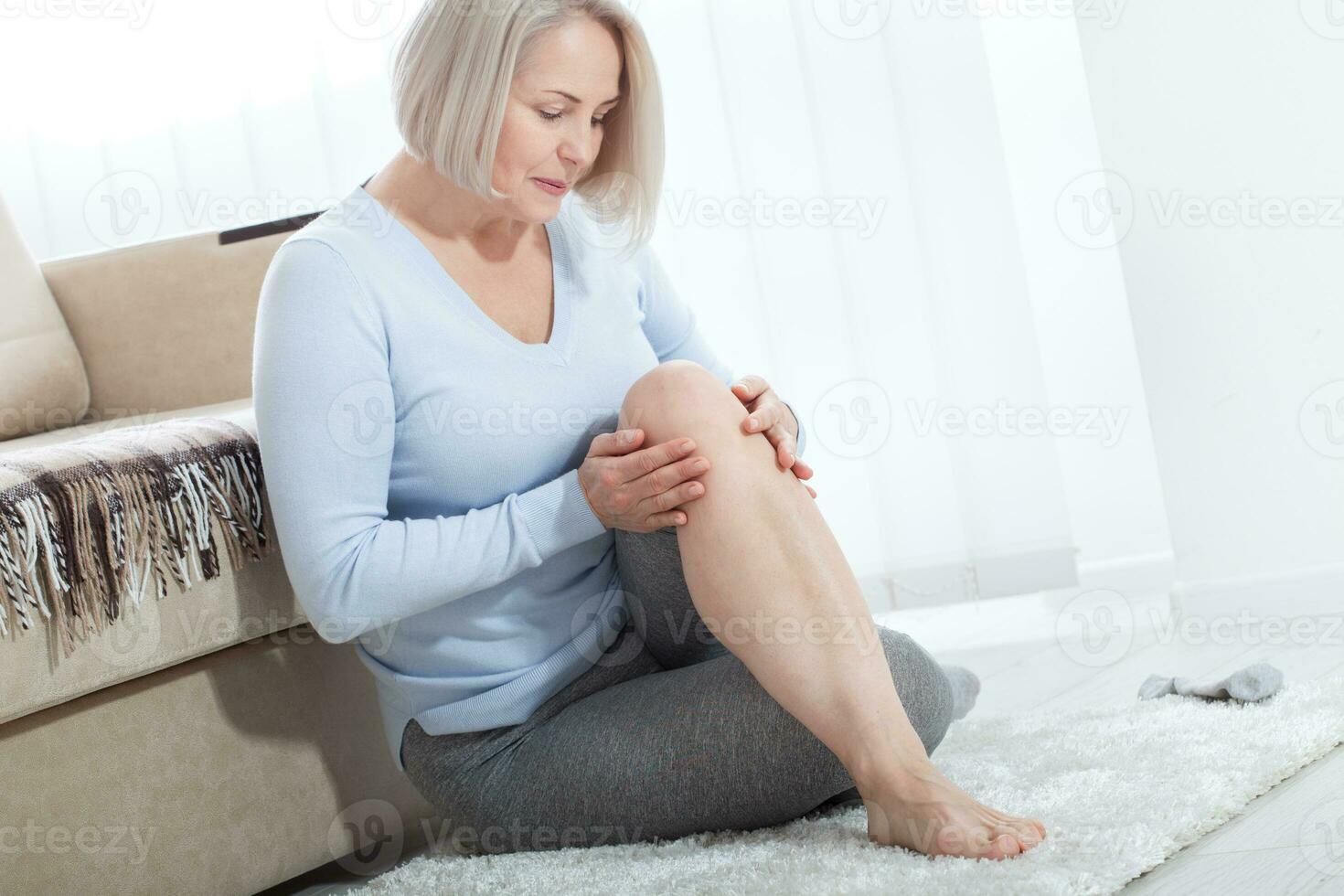 âge moyen femme Souffrance de douleur dans jambe à maison, fermer. physique blessure concept. photo