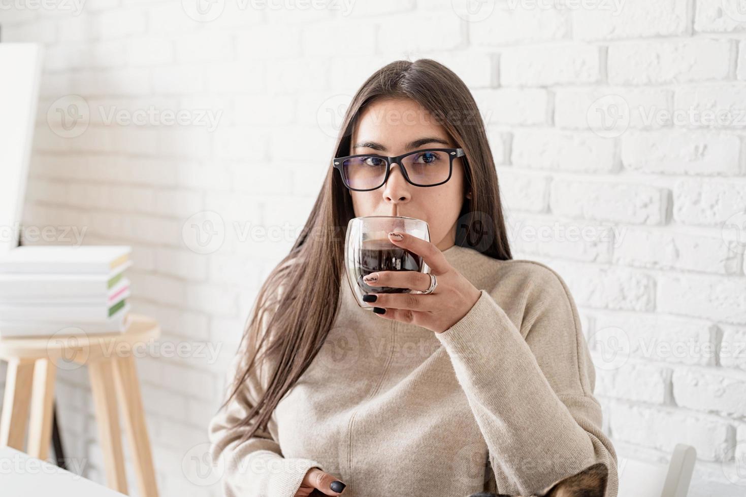 jeune femme buvant du café noir chaud photo