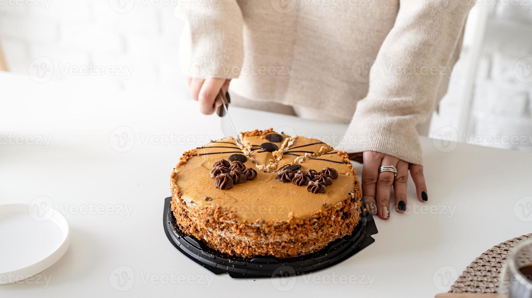 gros plan des mains de la femme coupant un gâteau photo