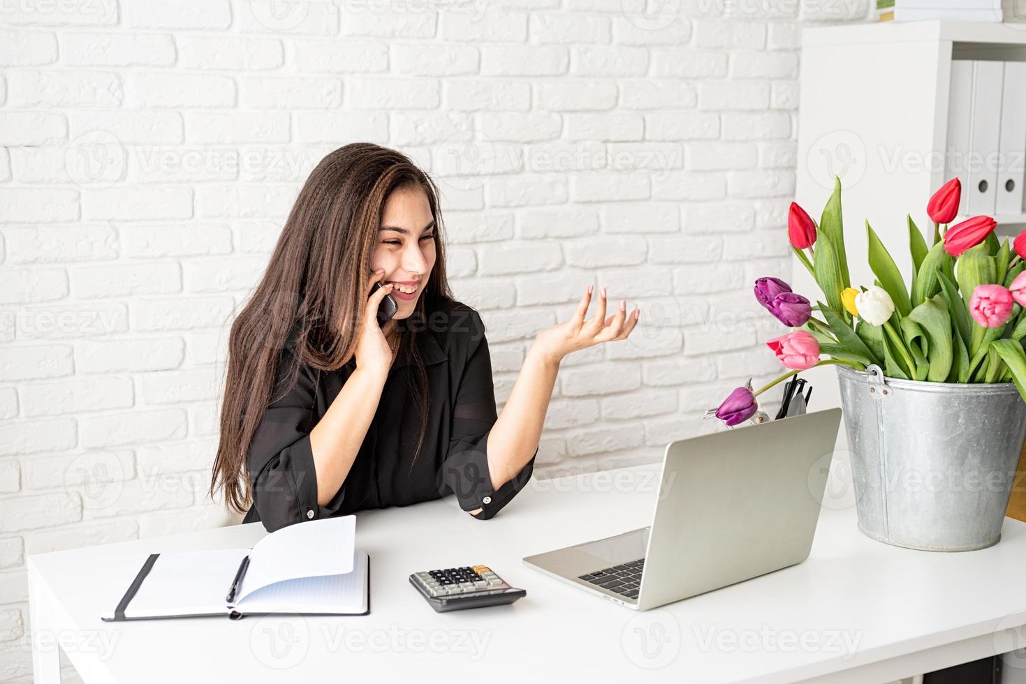 femme fleuriste parlant au téléphone et riant, travaillant au bureau photo