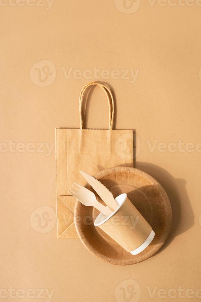 sac jetable et vaisselle tasse, assiette et fourchette en bois, couteau photo