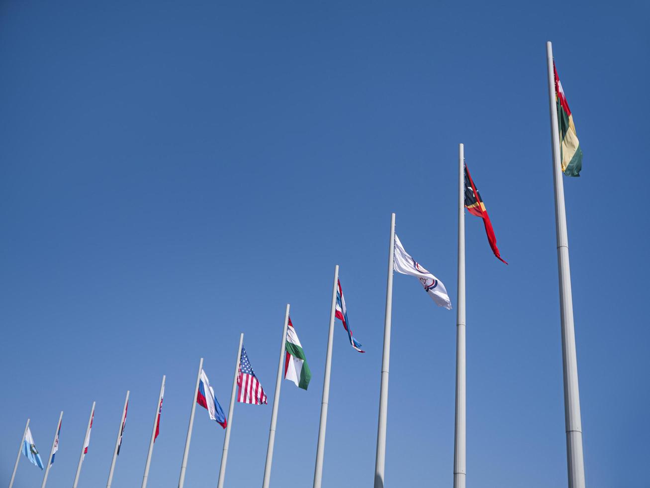 ville d'adler, russie - août 2019, drapeaux des pays du monde sur des mâts de drapeau dans le parc olympique photo