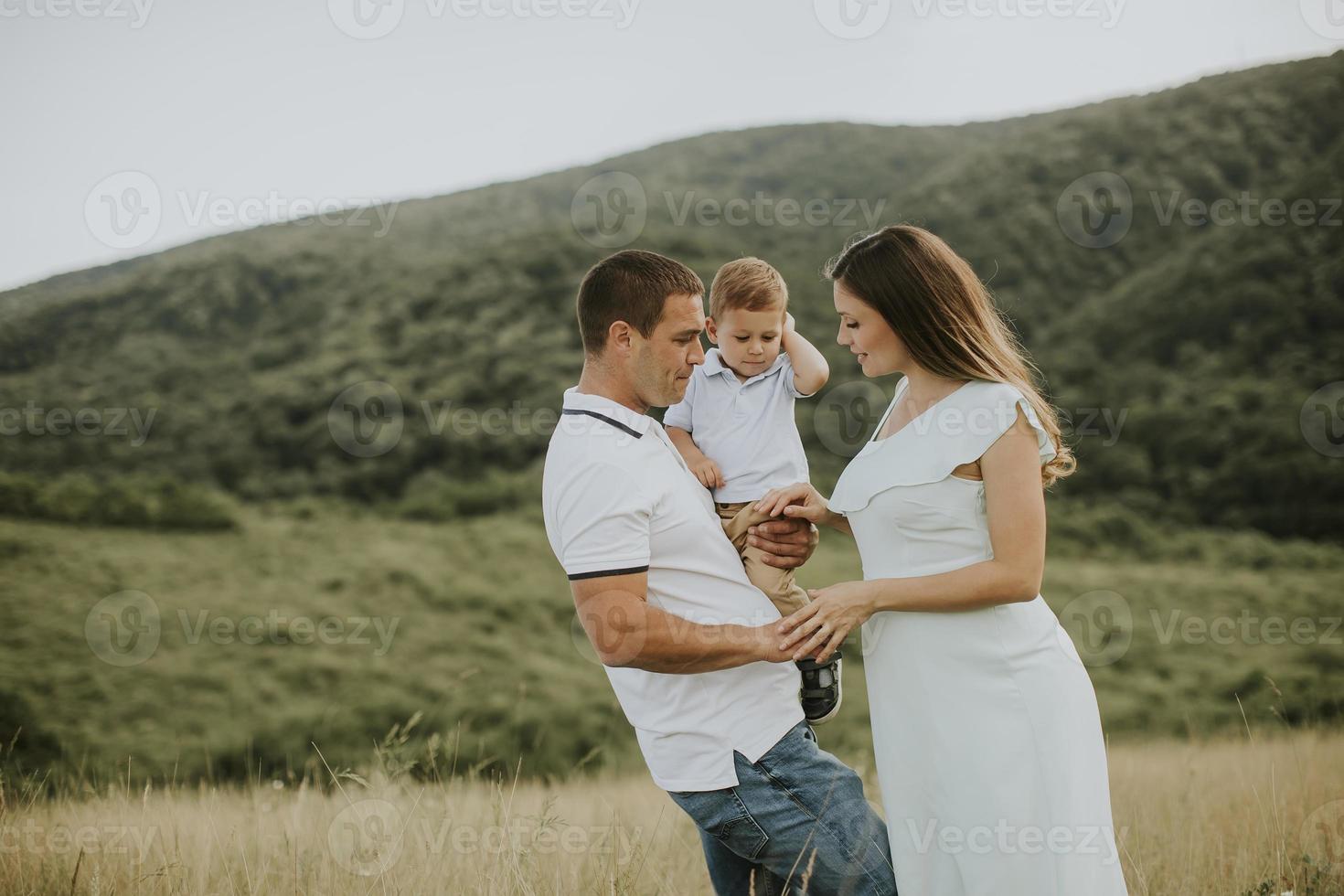 jeune famille avec mignon petit garçon s'amusant à l'extérieur sur le terrain photo