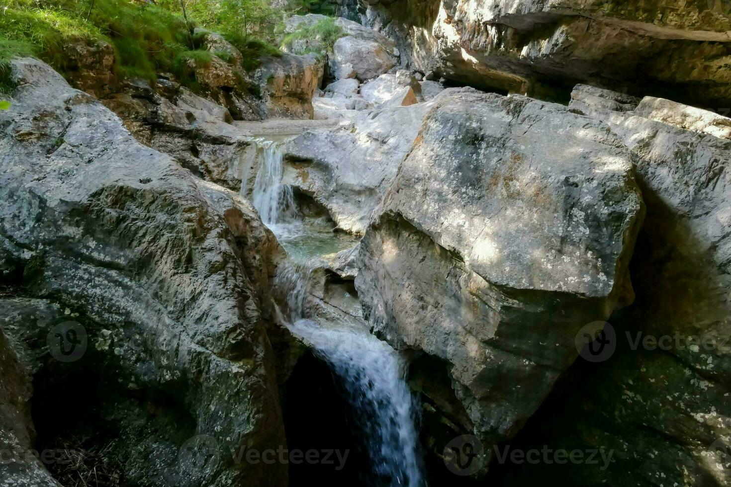 une cascade écoulement par une rocheux canyon photo