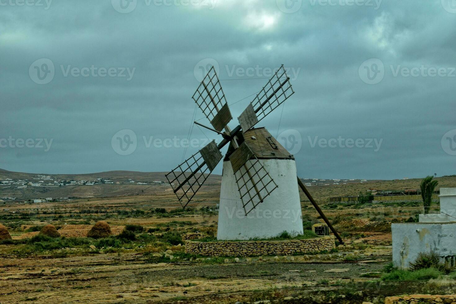 vide mystérieux montagneux paysage de le centre de le canari île Espagnol fuerteventura avec une nuageux ciel et original Moulins à vent photo