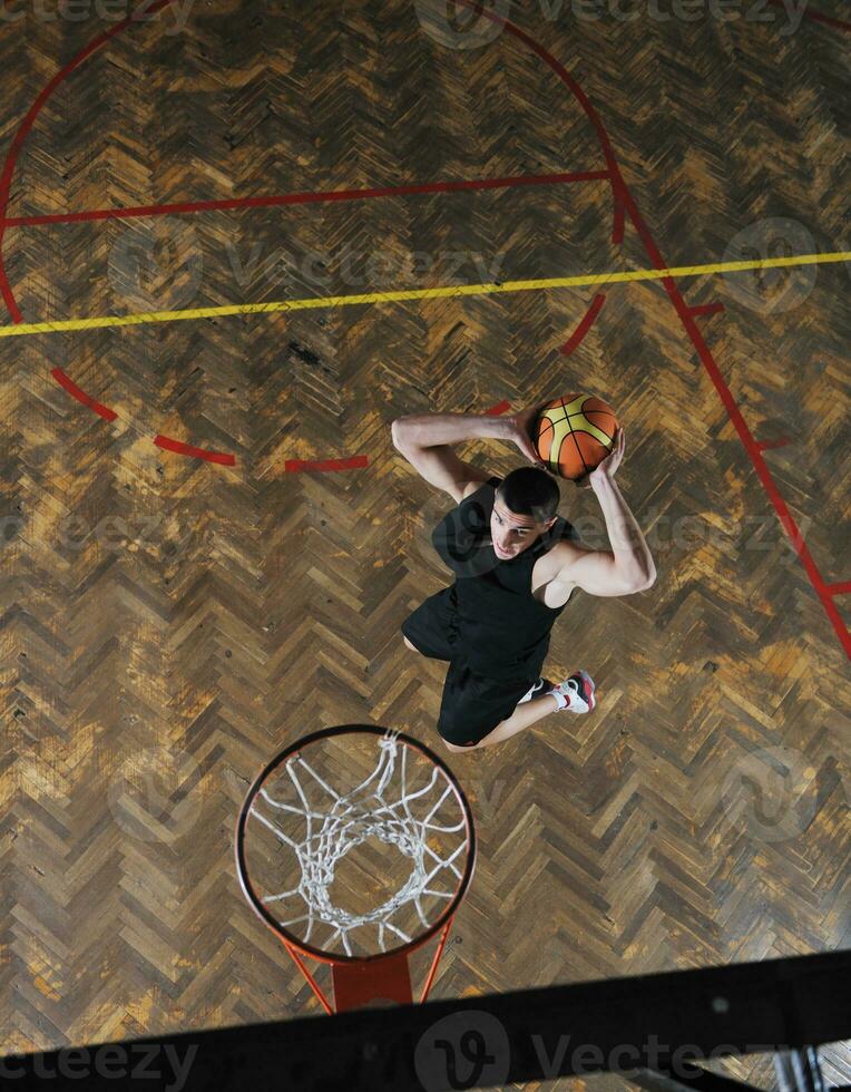 une homme est sauter en haut à tremper une basketball photo