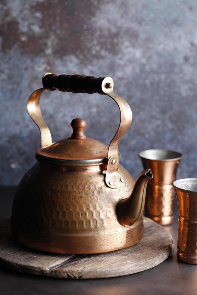 théière marocaine antique sur un plateau en bois photo