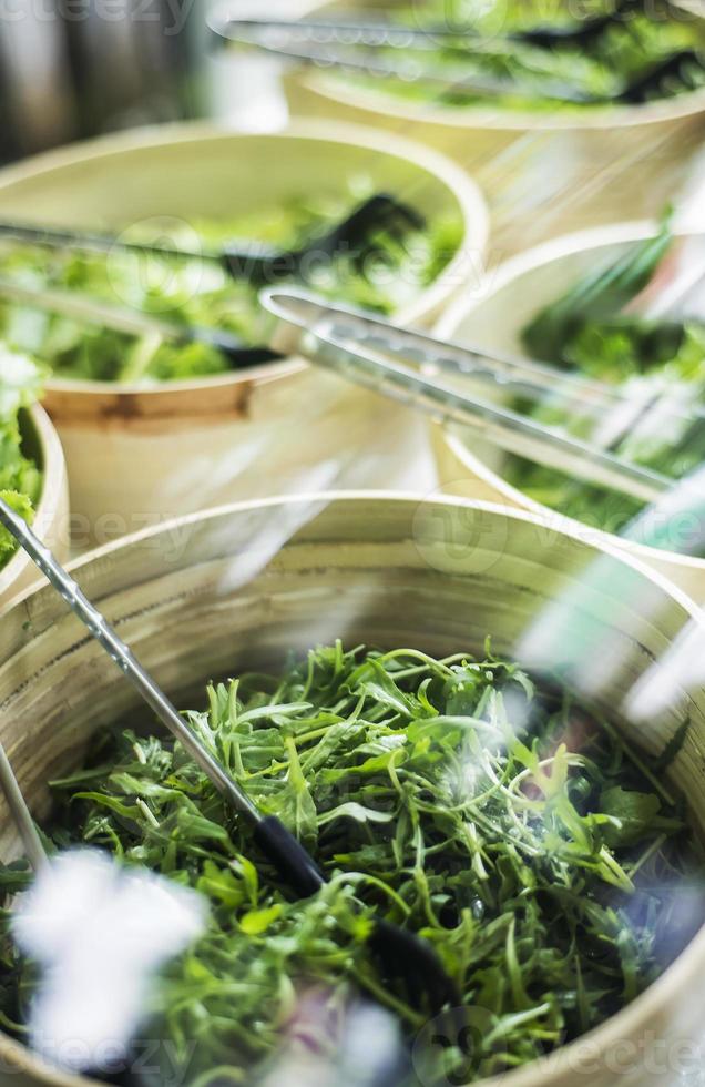 bols de feuilles de laitue verte biologique fraîche dans un bar à salades photo