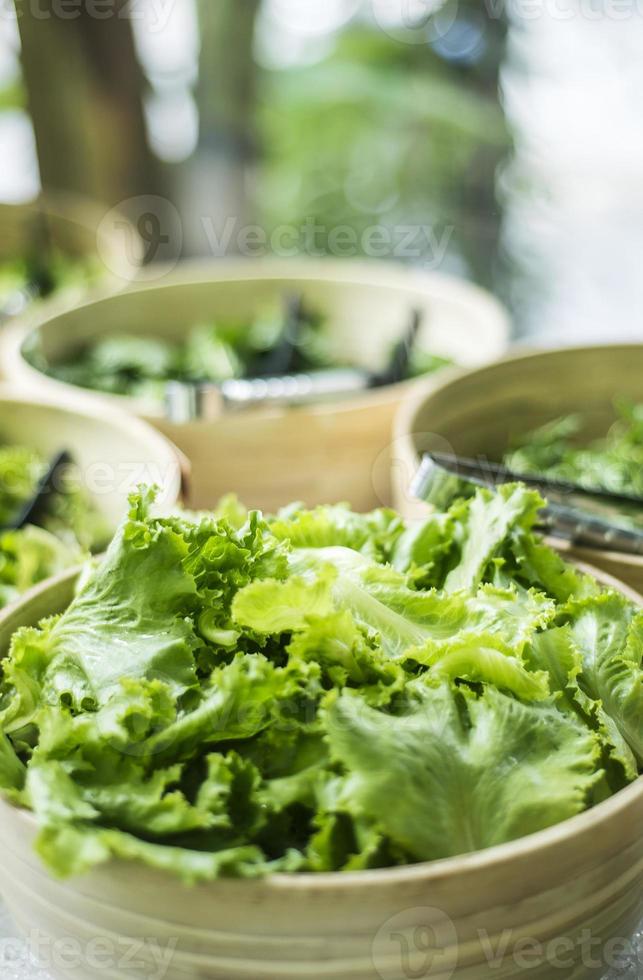 bols de feuilles de laitue verte biologique fraîche dans un bar à salades photo