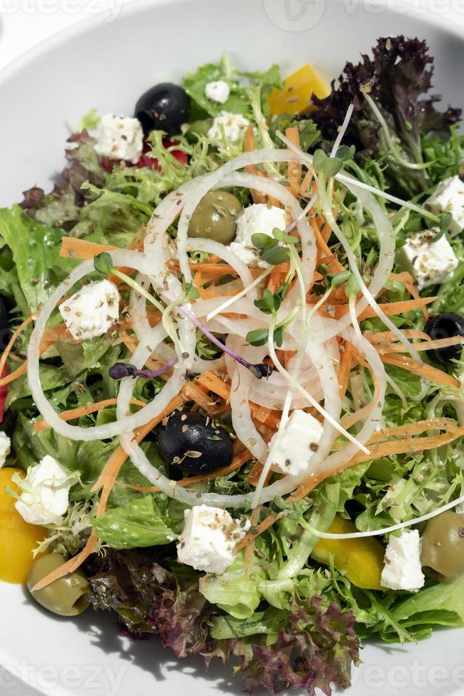 salade grecque avec fromage feta et olives avec vinaigrette aux agrumes sur table en bois photo