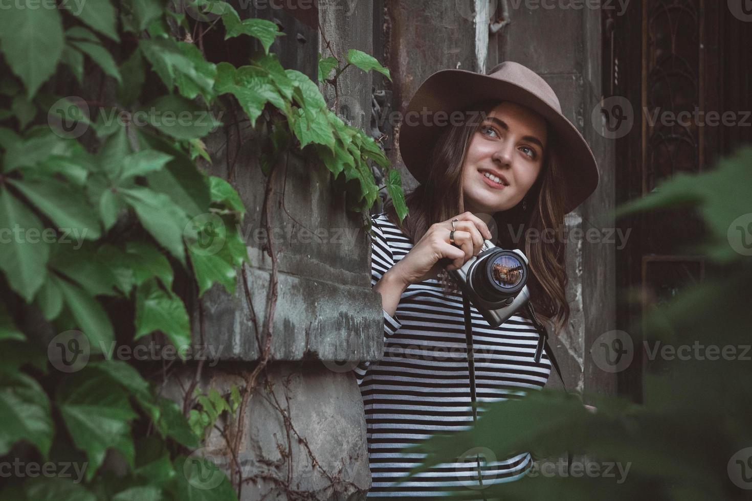 belle femme au chapeau prend une photo avec un vieil appareil photo
