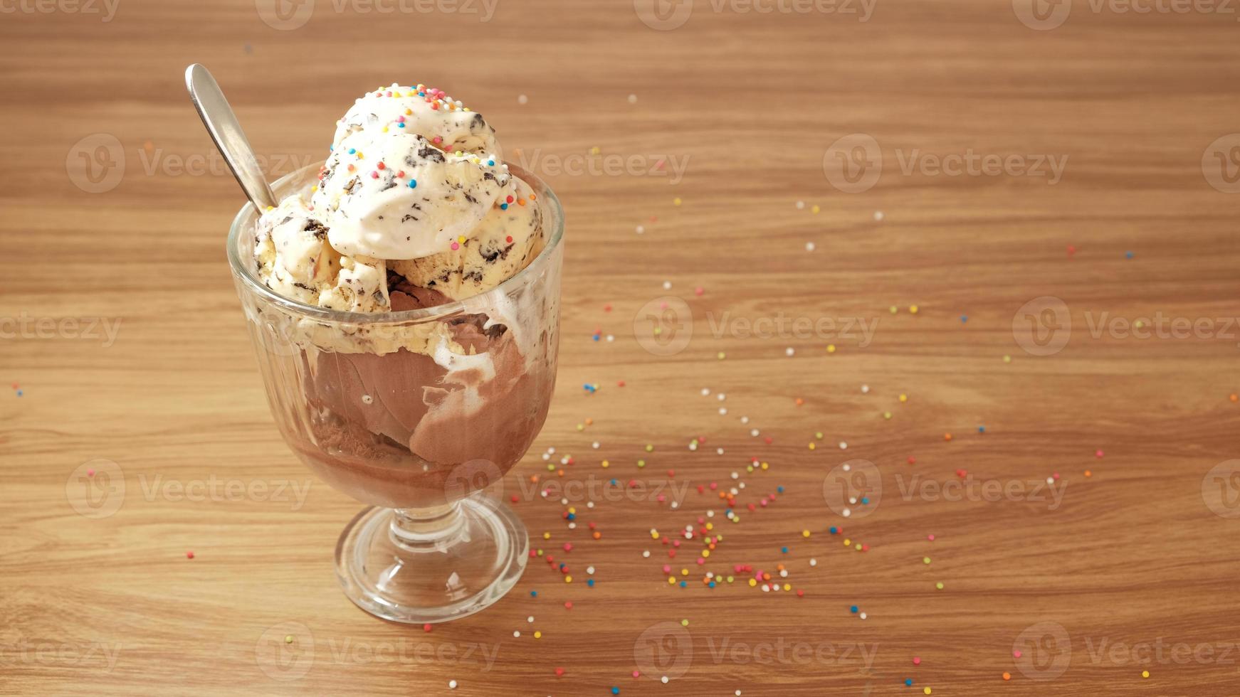 crème glacée aux pépites de chocolat avec garnitures colorées dans des tasses en verre transparent. photo